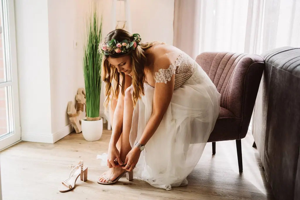 Hochzeitsfotograf Langeoog – Braut beim Anziehen der Schuhe vor der Trauung