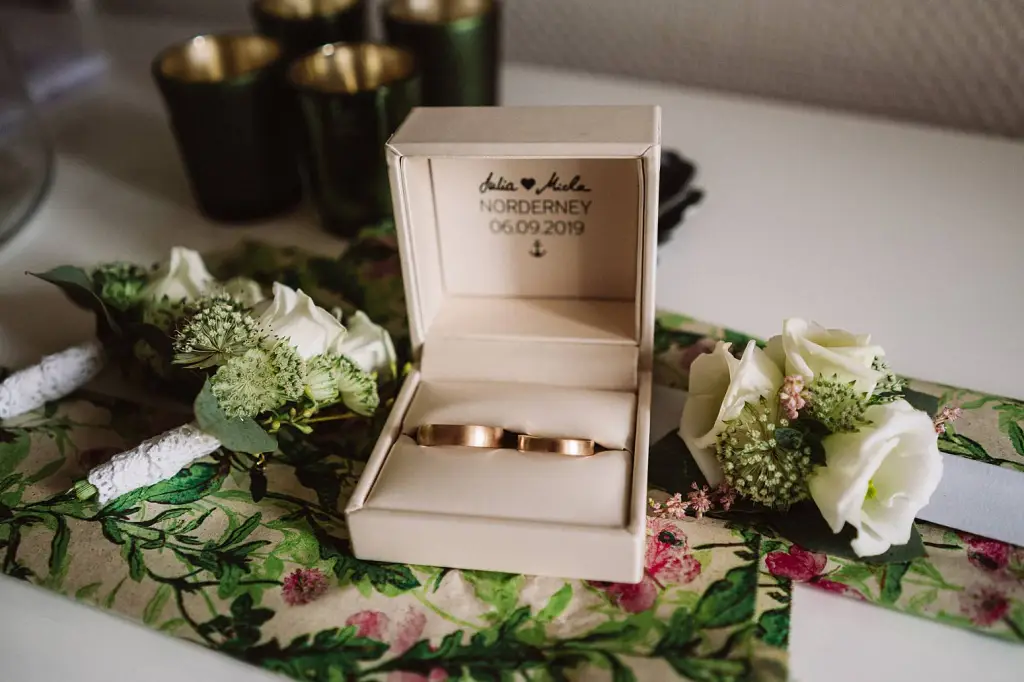 Hochzeitsfotograf Norderney – Eheringe und Trauringe auf einem Holztisch