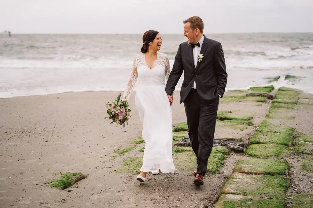 Hochzeitsfotograf Norderney – Lachendes Brautpaar beim Spaziergang