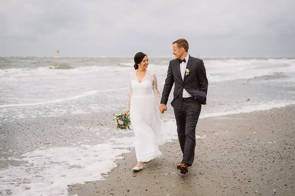 Hochzeitsfotograf Norderney – Brautpaar läuft am Strand