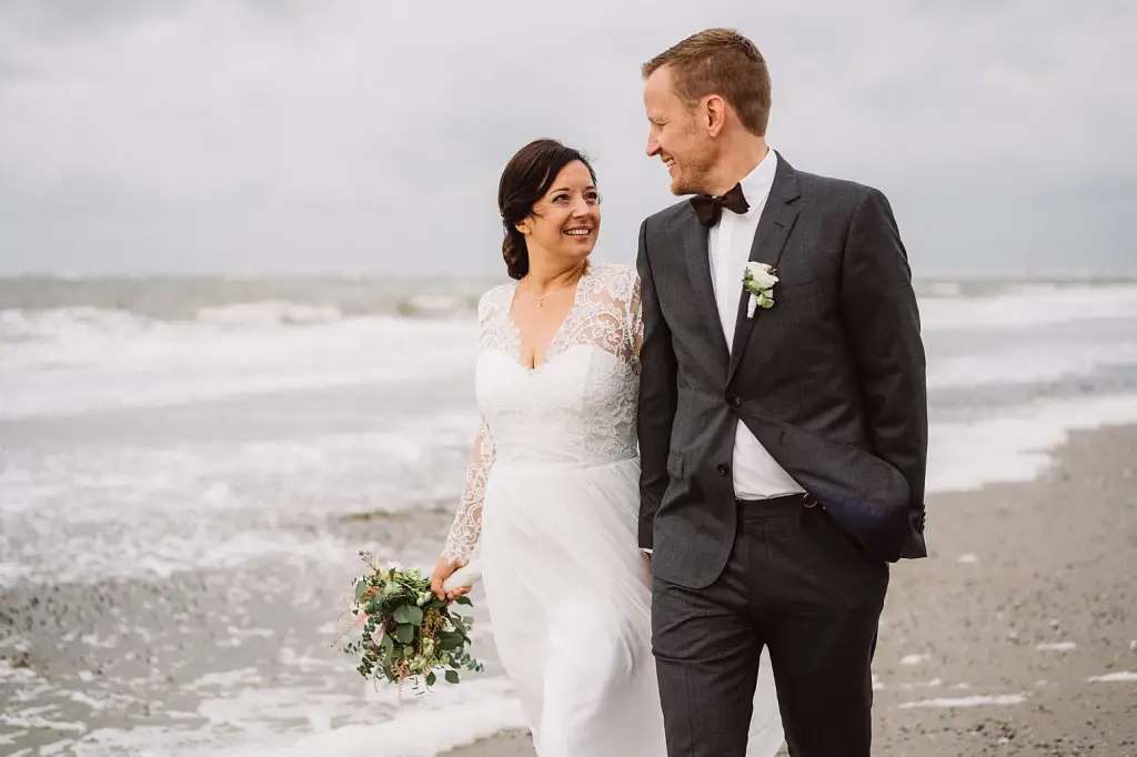 Hochzeitsfotograf Norderney – Brautpaar am windigen Strand von Norderney