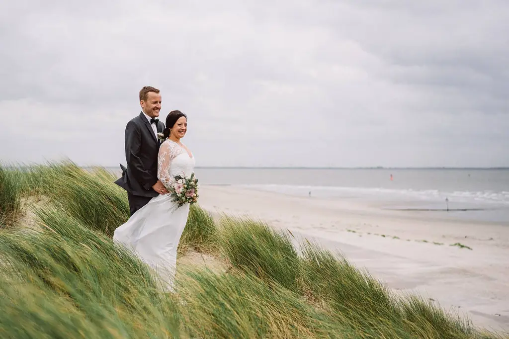 Hochzeitsfotograf Norderney – Brautpaar in den Dünen mit Blick auf das Meer