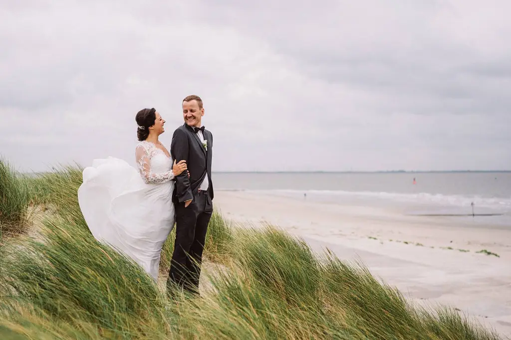Hochzeitsfotograf Norderney – Lachendes Brautpaar in den Dünen