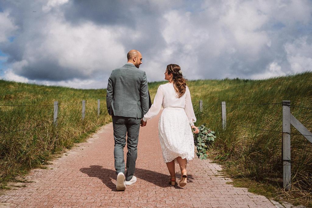 Brautpaar auf dem Weg zum Strand auf Baltrum