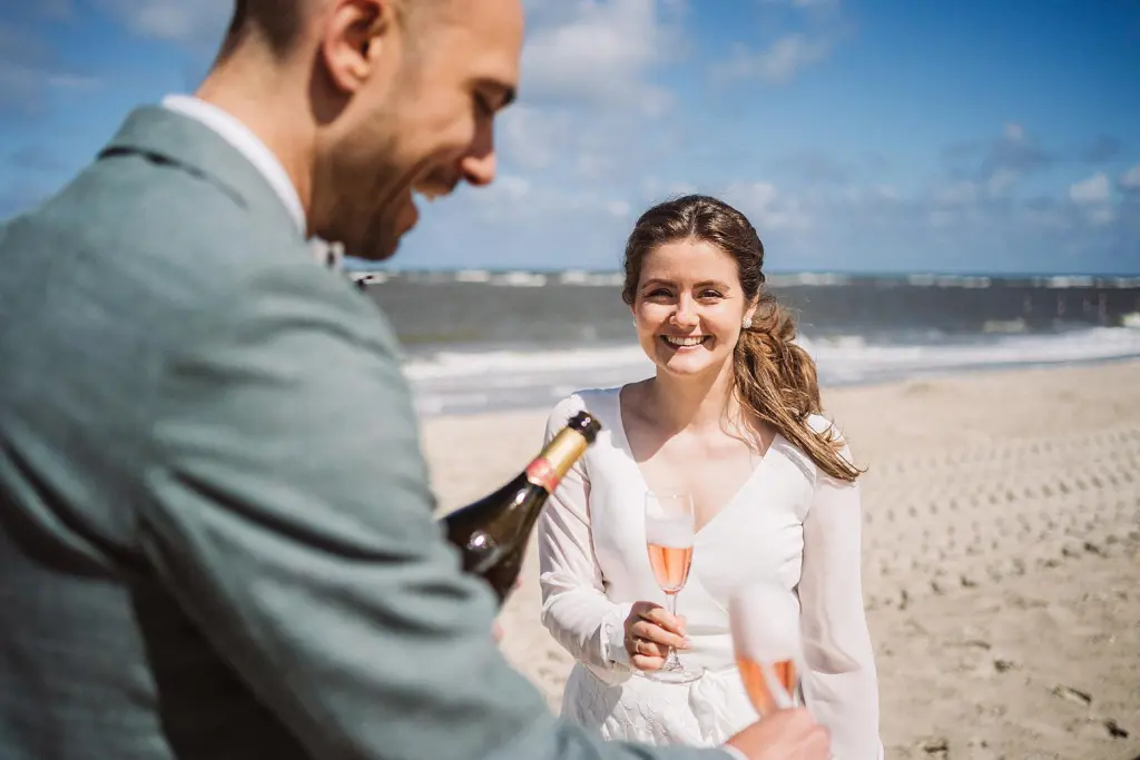 Brautpaar lacht auf dem beim Anstossen mit Sekt