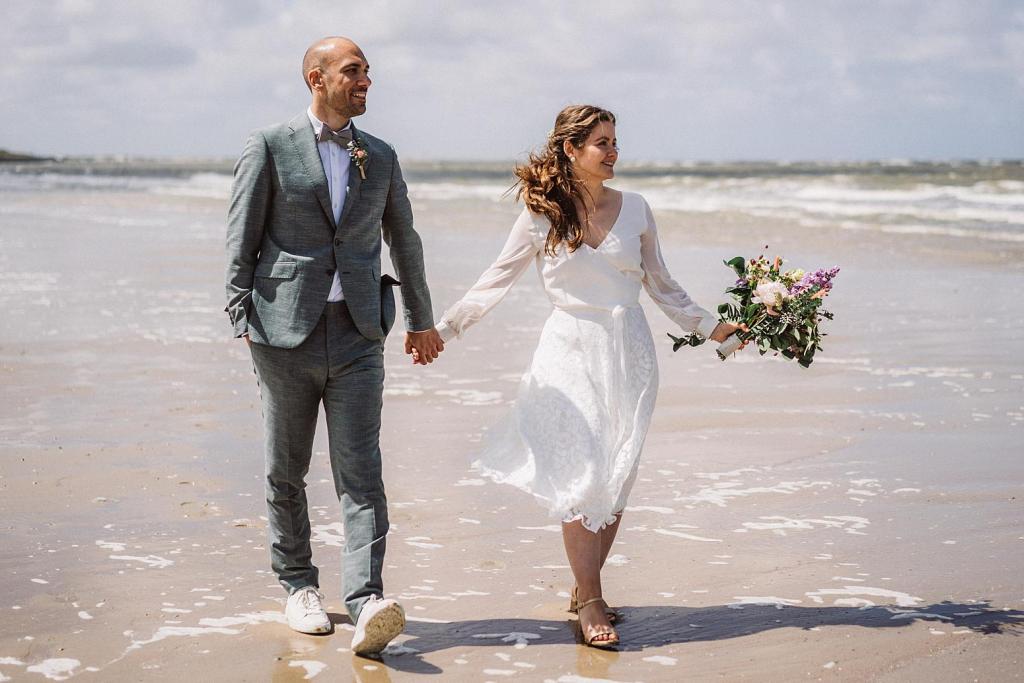 Brautpaar Hand in Hand am Strand