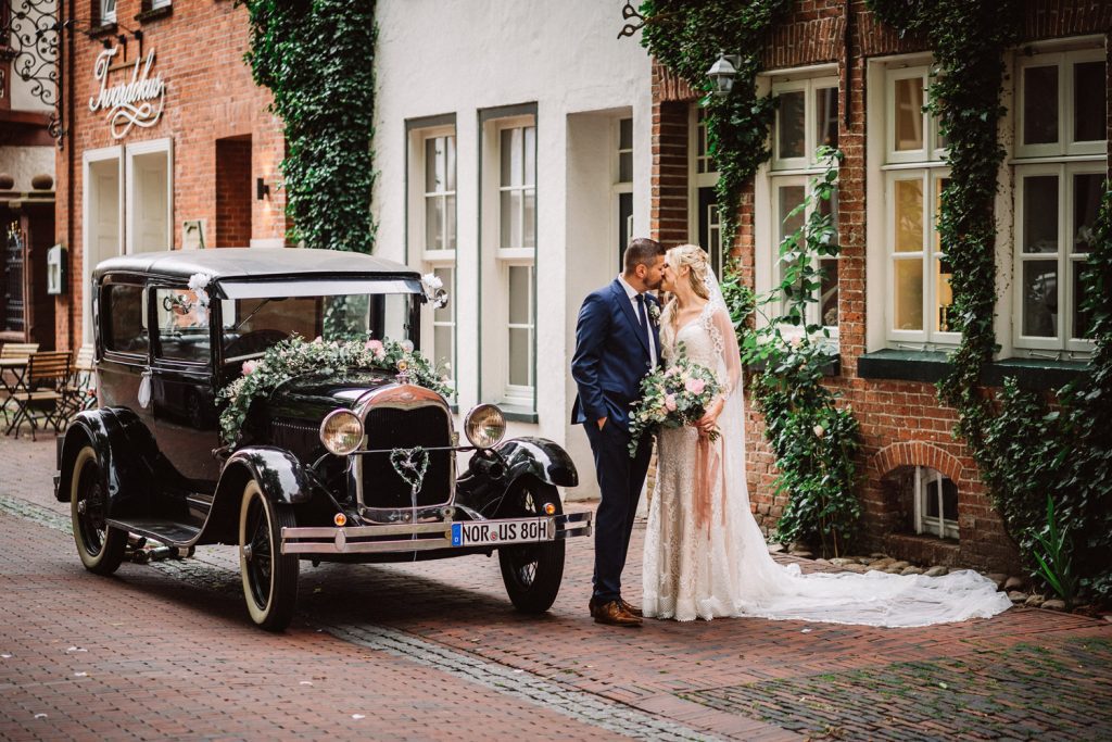 Brautpaar mit Oldtimer bei der Hochzeit in Aurich – Hochzeitsfotograf Ostfriesland