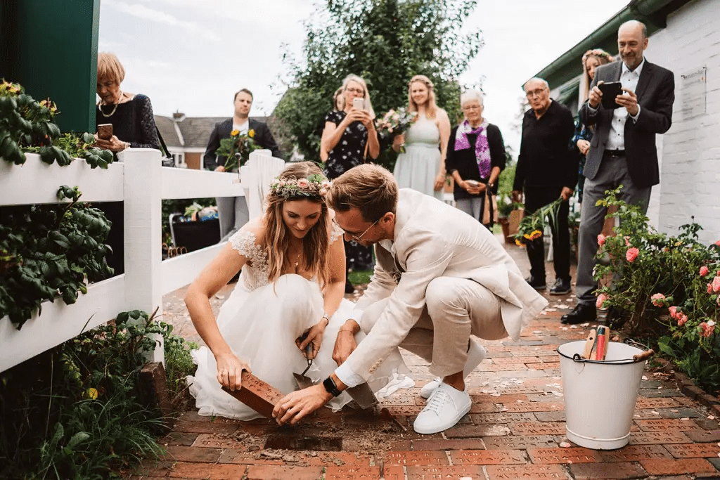 Brautpaar setzt den Hochzeitsklinker nach der Trauung im Seemannshus Langeoog – Hochzeitsfotograf Elmar Tapper
