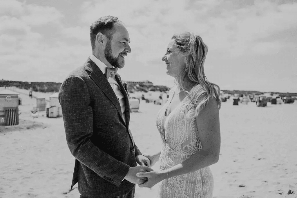 Brautpaar blickt sich bei der Strandhochzeit auf Juist an – Hochzeitsfotos am Meer mit Nordseestimmung