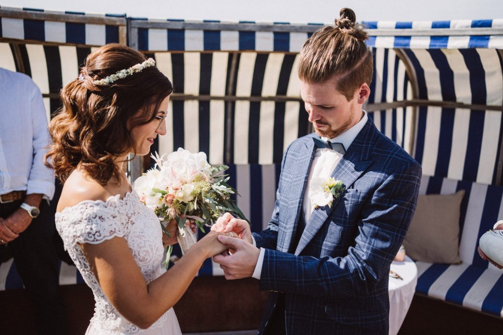 Braut und Bräutigam stecken sich die Ringe an bei der Trauung am Strand von Norderney