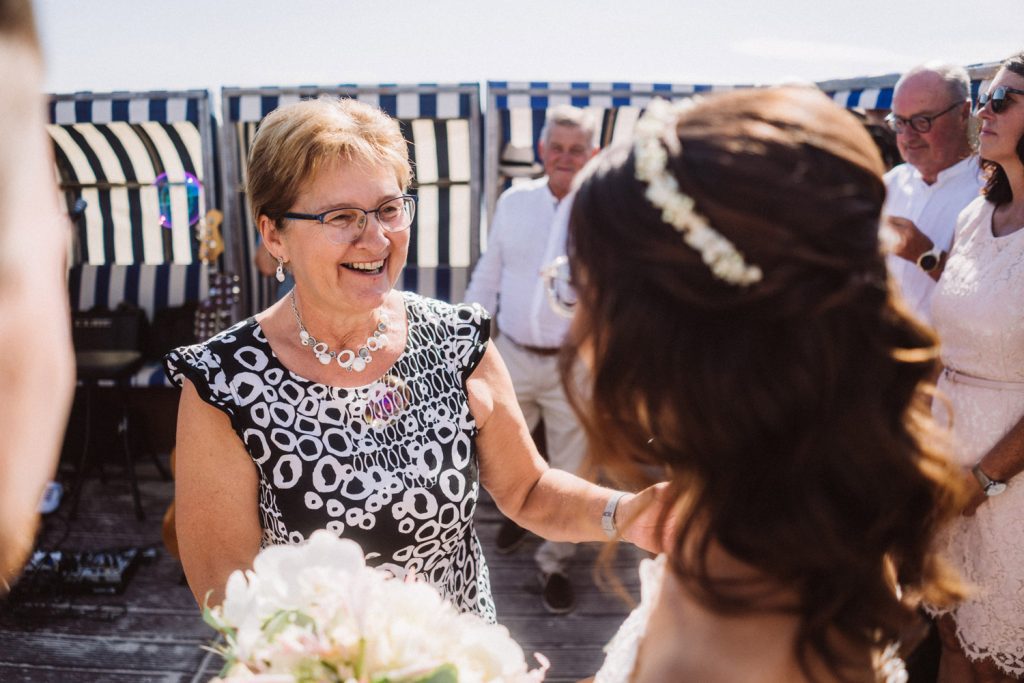 Braut bekommt Glückwünsche nach der Trauung am Strand von Norderney
