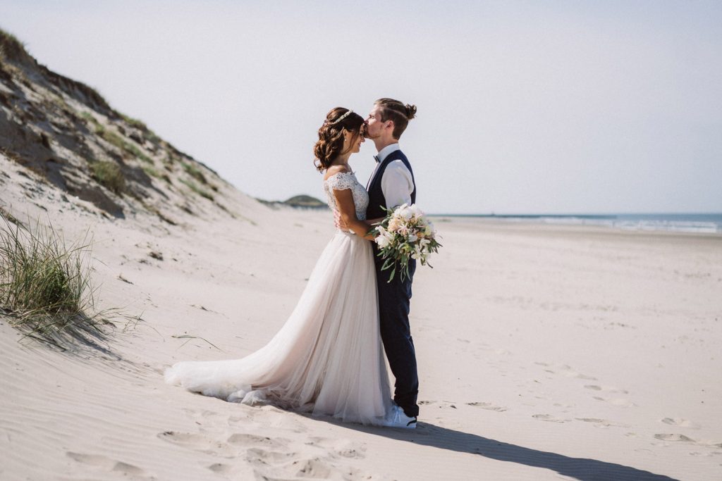 Hochzeitspaar küsst sich in den Dünen von Norderney beim romantischen Strandshooting