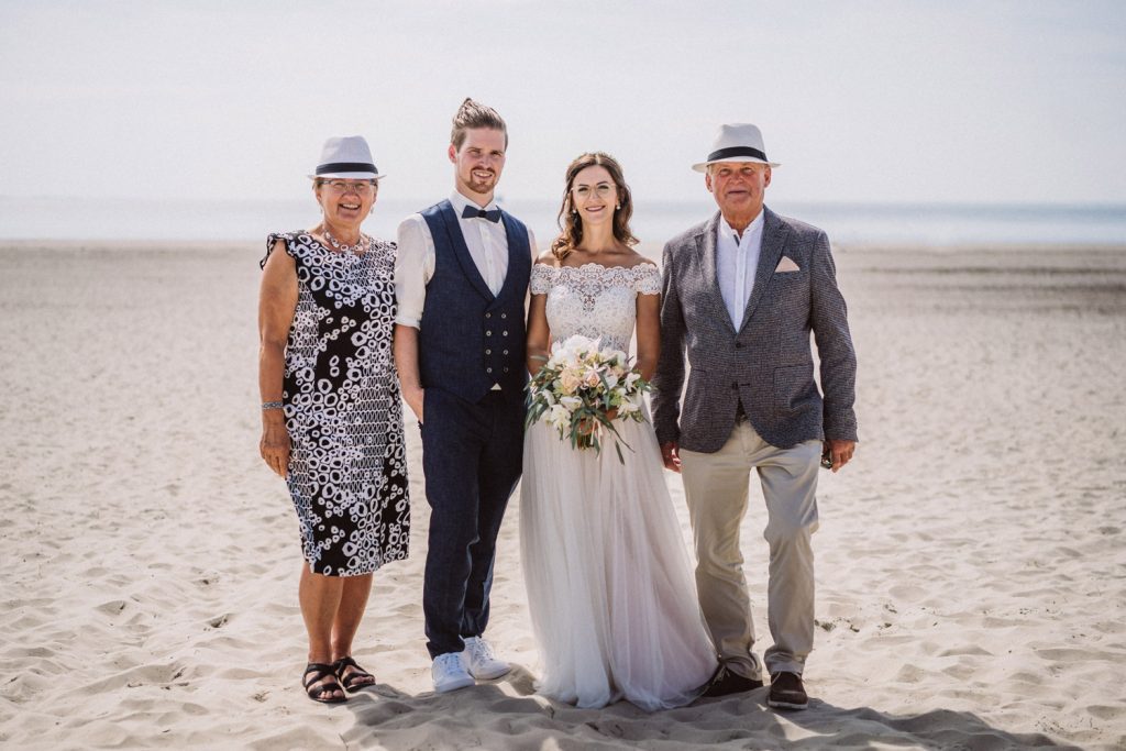 Brautpaar mit Eltern beim Familienfoto am Strand von Norderney
