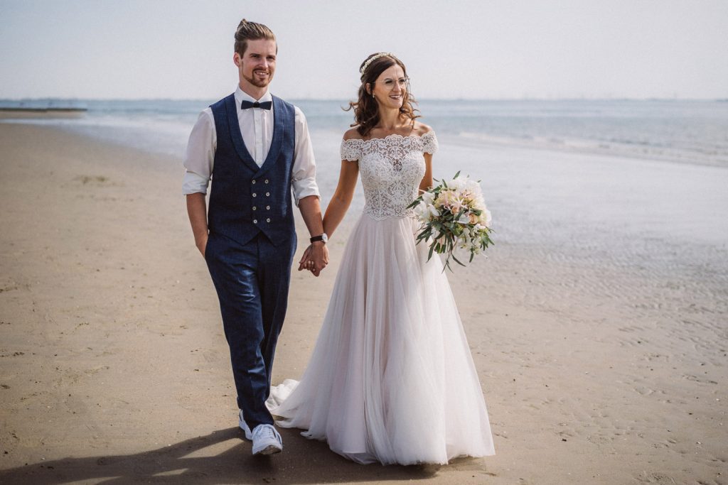 Brautpaar beim Fotoshooting am Strand von Norderney mit Blick aufs Meer