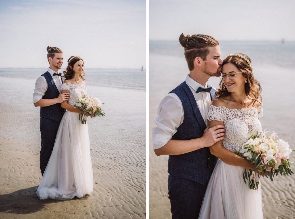 Brautpaar steht vor dem Badekarren am Strand von Norderney nach der Trauung