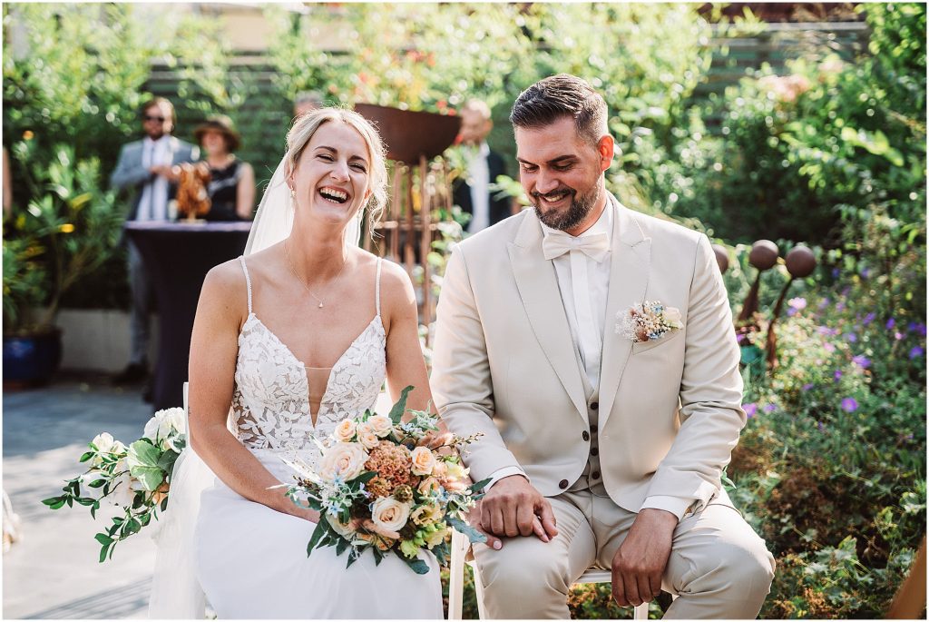 Brautpaar lacht während der freien Trauung im Müggenkrug Oldenburg – gelöste und fröhliche Stimmung