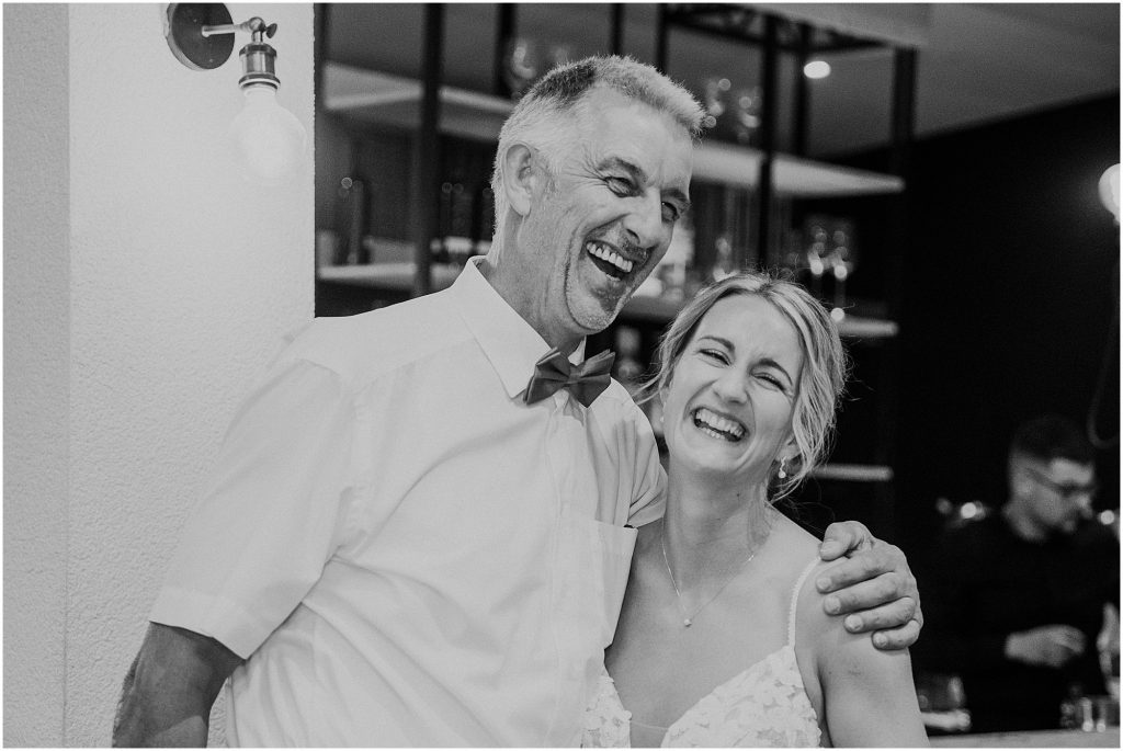 Braut lacht mit einem Hochzeitsgast während der Feier im Müggenkrug Oldenburg – herzlicher Moment