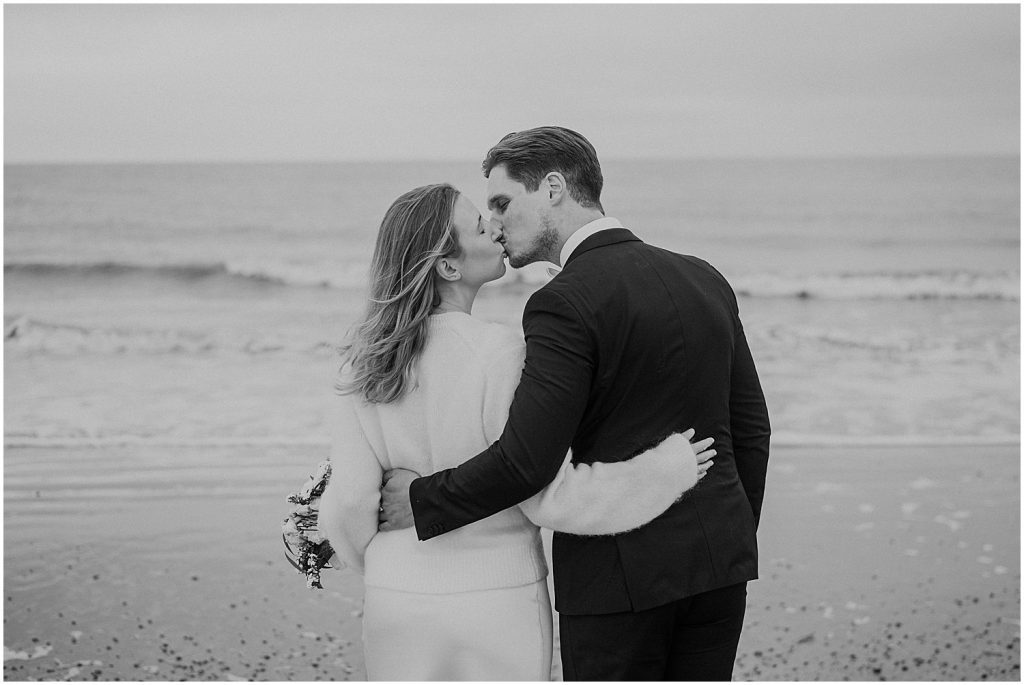 Brautpaar küsst sich am Meer auf Norderney bei einer Winterhochzeit