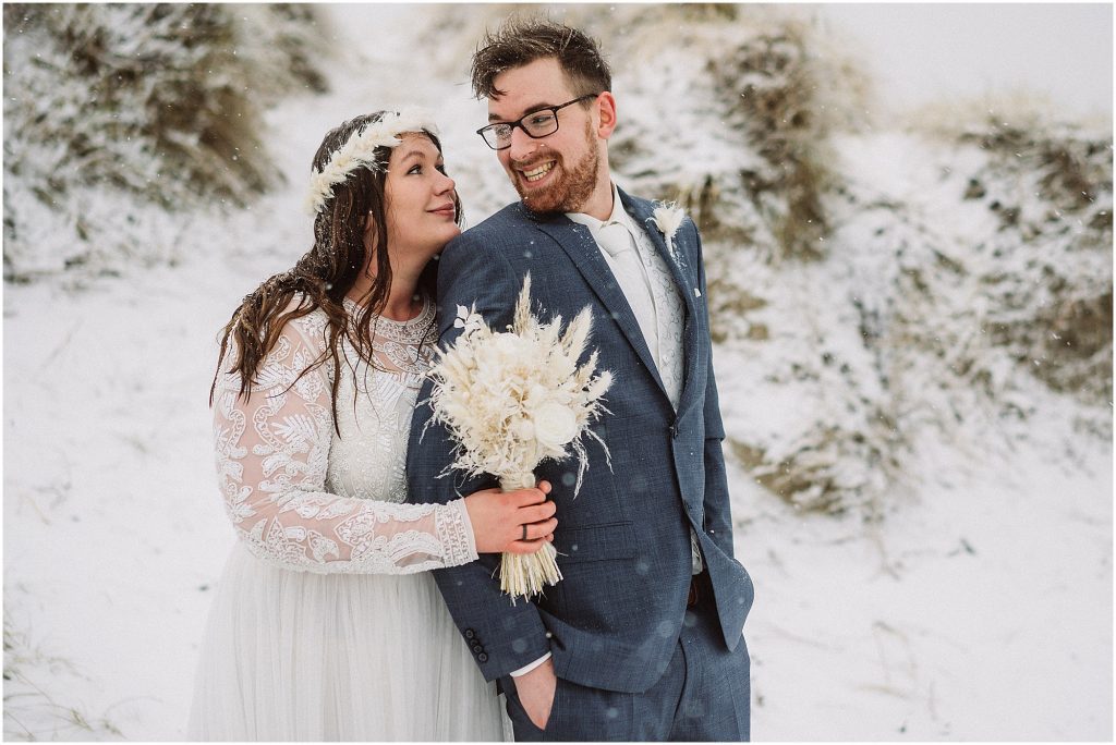 Brautpaar lacht im Schneefall – authentische Hochzeitsreportage auf Norderney im Winter